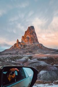 View of car on rock formation against sky