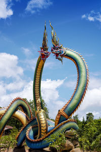 Low angle view of sculpture against blue sky