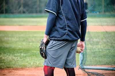 Man holding umbrella while standing on field