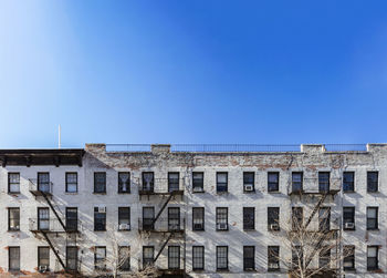 Low angle view of buildings against clear blue sky