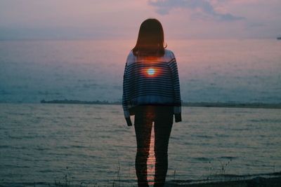 Rear view of woman at sunset