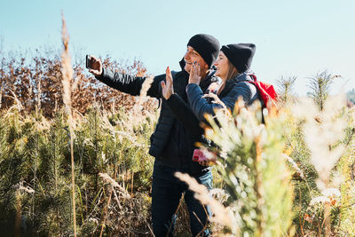 Couple waving during video call sending greetings from vacation trip. leisure time close to nature