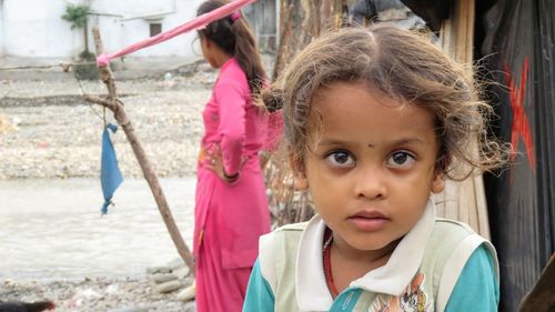 Portrait of cute girl with arms raised