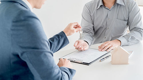 Midsection of man and woman sitting on table