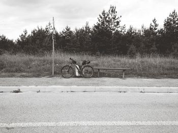 Bicycle by road against sky