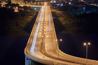 Highway at night lights. fast car light path, trails and streaks on interchange bridge road. night