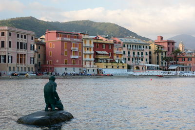 Buildings by sea against sky in city