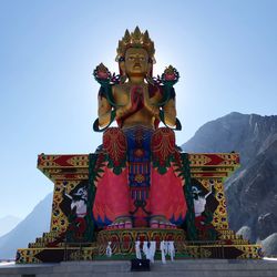 Low angle view of statue against temple against clear sky