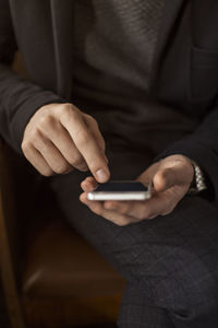 Midsection of man using mobile phone