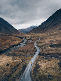Road by mountains against sky