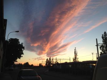 Cars on road against sky during sunset