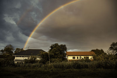 Scenic view of rainbow over buildings against sky