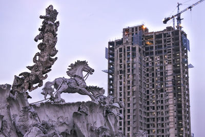 Statue against building in city