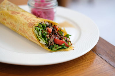 Vegan wrap stuffed with quinoa, black bean, mango, cashew nut, bell pepper