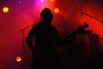 Silhouette man playing guitar at music concert