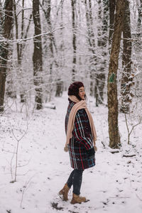 Rear view of woman walking on snow covered landscape