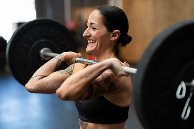 Young woman exercising with dumbbell in gym