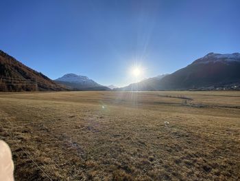 Scenic view of field against bright sun
