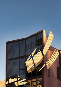 Low angle view of modern building against clear blue sky