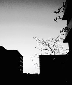 Low angle view of silhouette buildings against clear sky