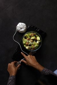 Cropped hand of person preparing food on table