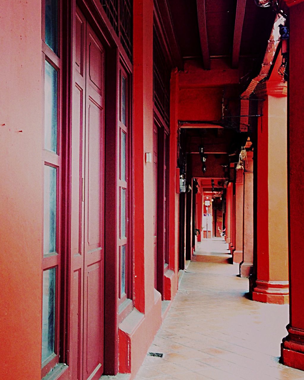 architecture, built structure, red, building exterior, the way forward, in a row, door, narrow, house, diminishing perspective, corridor, empty, residential structure, building, long, walkway, alley, no people, residential building, day