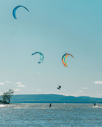 People paragliding over sea against sky