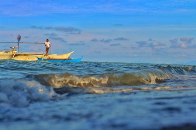 Man surfing in sea against sky