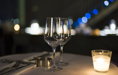 Close-up of wine glasses on illuminated table