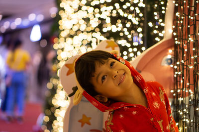 Cute girl standing against illuminated lights