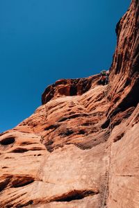 Low angle view of rock formation against clear blue sky