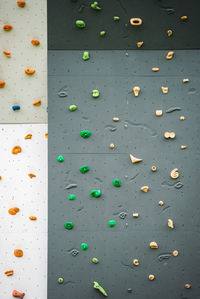 Abstract colorful of rock climbing wall with toe and hand hold studs., various colored grips at gym