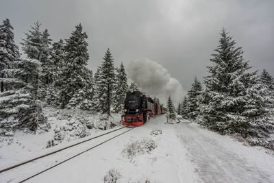 Train on snow covered landscape against sky