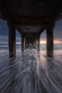 Under the manhattan beach pier during sunset