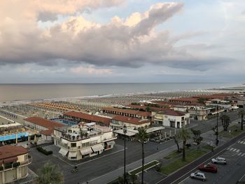 High angle view of city by sea against sky