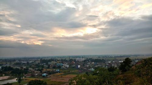 Aerial view of city by sea against sky