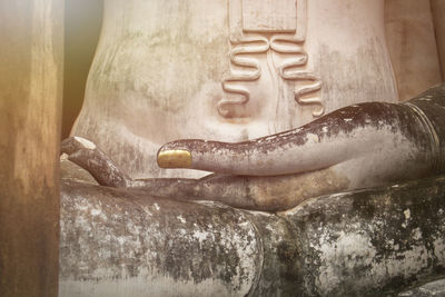 Close-up of buddha statue against building