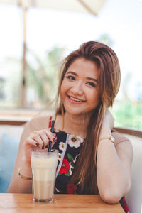 Portrait of smiling woman drinking glass