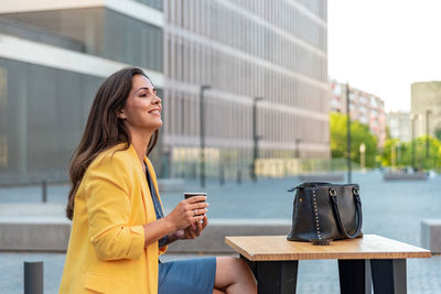 Woman holding coffee cup on table