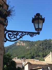 Low angle view of street light by building against sky