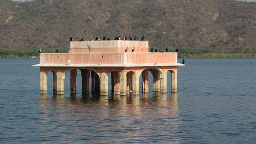 Built structure by lake against mountain