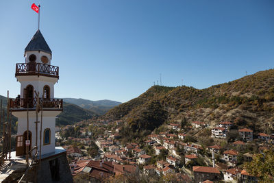 High angle view of bell tower amidst mountains against clear sky