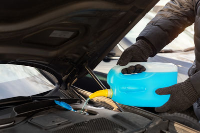 Cropped hand of man cleaning car