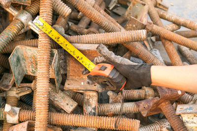 Cropped hand of worker holding measuring tape on work tools at factory