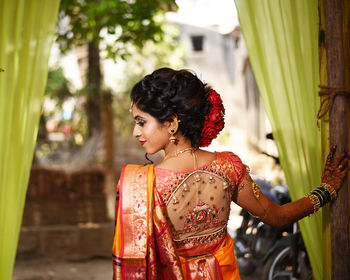 Rear view of bride wearing sari standing at wedding ceremony