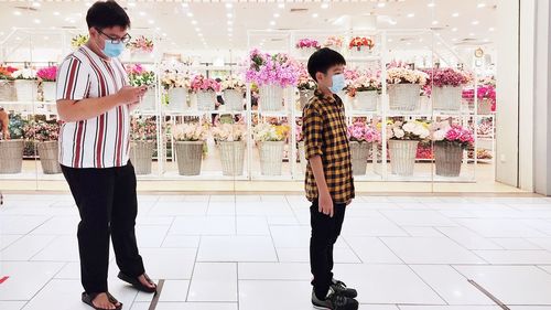 Full length of friends standing on tiled floor