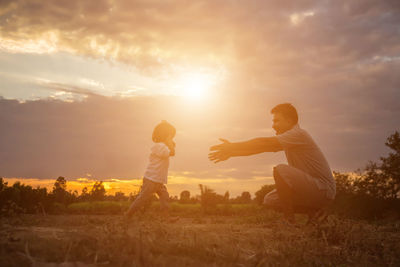 People on field against sky during sunset