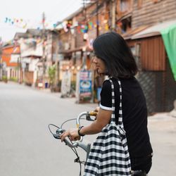 Side view of woman riding bicycle on street