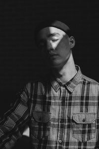 Young man with closed eyes in darkroom