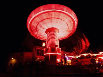 Low angle view of illuminated ferris wheel against sky at night